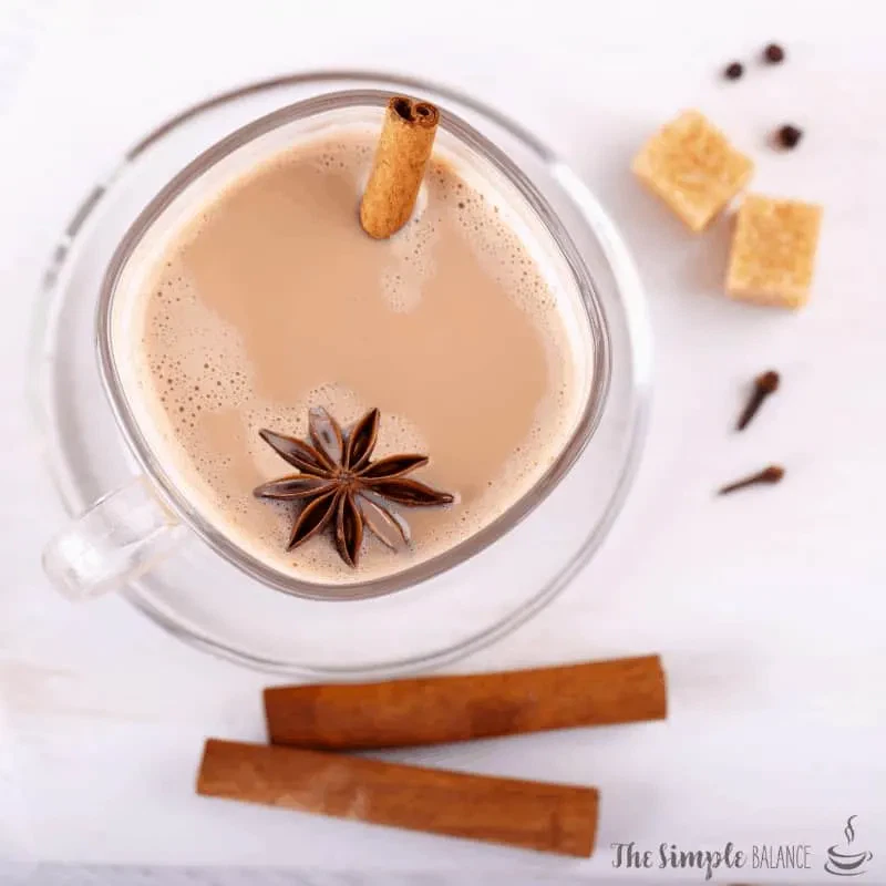 Inviting glass of spiced chai tea with cinnamon, anise, and sugar cubes. Perfect for cozy moments.