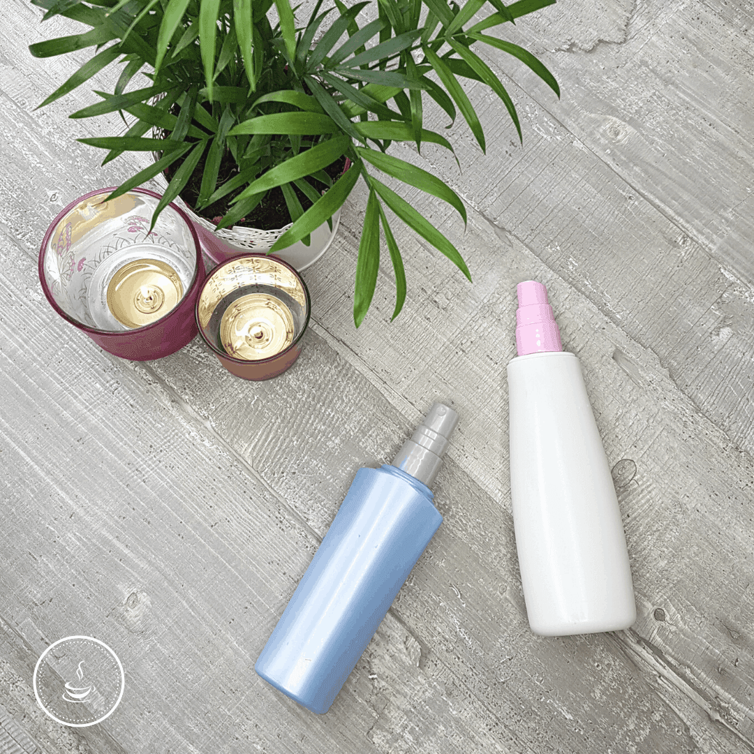 Tranquil self-care setup with candles, plant, and colorful bottles on a rustic wooden table.