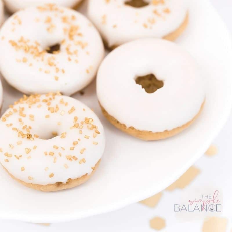 Elegant white iced donuts with golden sprinkles celebrate indulgence and joy. Perfect for any occasion!