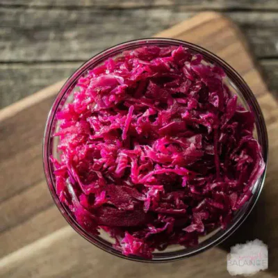 Bright, finely shredded red cabbage in a clear bowl, perfect for salads and garnishes.