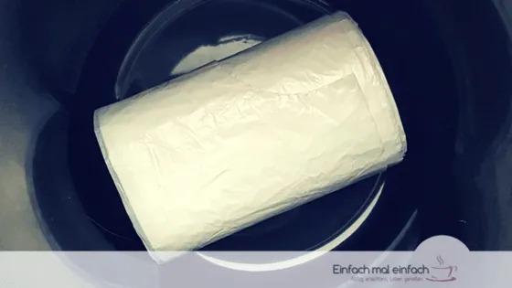 Simple space-saving hacks 5 White trash bag roll at the bottom of a dark trash bin.