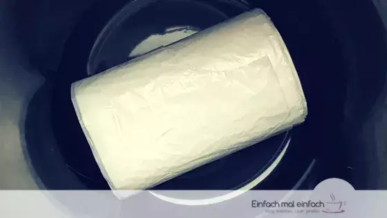 Simple space-saving hacks 6 White trash bag roll at the bottom of a dark trash bin.