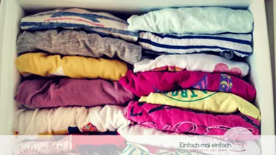 Simple space-saving hacks 7 Colorful kids shirts foldet and stacked like CDs in a drawer organizer.