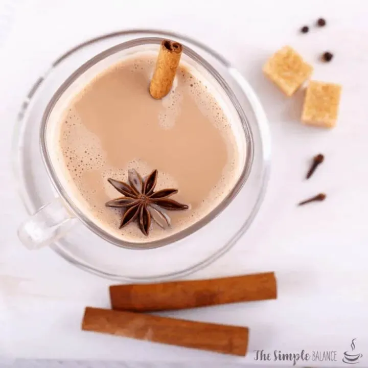 Inviting glass of spiced chai tea with cinnamon, anise, and sugar cubes. Perfect for cozy moments.