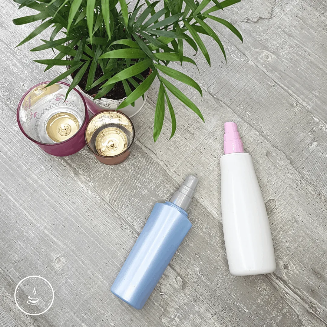 Tranquil self-care setup with candles, plant, and colorful bottles on a rustic wooden table.