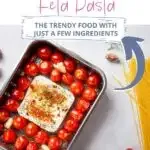Delicious baked feta pasta with cherry tomatoes and garlic in a modern metallic dish.