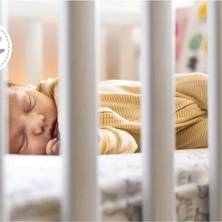 Cozy baby sleeping peacefully in a crib, radiating warmth and innocence under soft light.