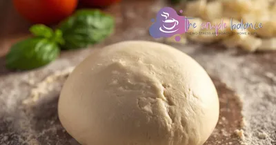 Fresh pizza dough on a countertop.